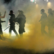 Police confront demonstrators as Black Lives Matter supporters demonstrate in Portland, Oregon on July 4, 2020 for the thirty-eighth day in a row at Portland’s Justice Center and throughout Portland, with a riot declared about 12.20 am on July 5. CS tear gas and less-lethal weapons were used, and multiple arrests were made.